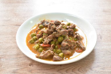  Hindistan cevizi sütlü patlıcanla haşlanmış baharatlı biftek. Tabakta kırmızı köri çorbası.