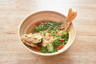  Baharatlı haşlanmış kırmızı levrek balığı ve Tom yum çorbası kasede.