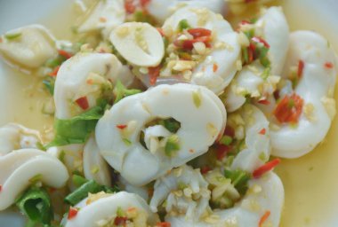  Tay baharatlı ve ekşi dilimlenmiş limon soslu kalamar salatası.