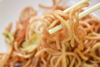 Kızarmış yakisoba Japon eriştesi dilimlenmiş domuz eti ve havuçlu kuru balık tabağı. 