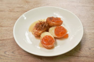  Kızarmış yumurta yarım kesilmiş tatlı tamarind sosu tabakta gevrek soğan.