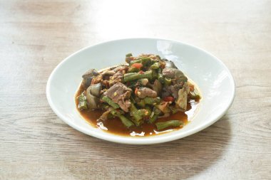  Baharatlı, kızarmış fasulye, uzun fasulye ve tavuklu ciğer ve tabakta acılı köri sosu.