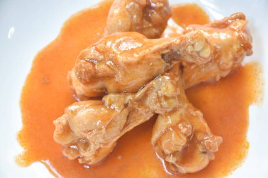  Buharda pişmiş tavuk budu ve tabakta kırmızı sos.