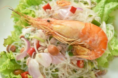  Karidesli cam erişte ve tabakta baharatlı domuz eti salatası.