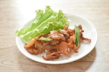  Kızarmış tuzlu domuz eti ve tabakta marul.