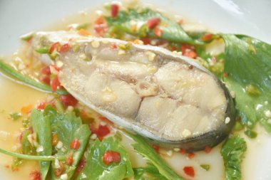  Acı biber ve limon soslu buğulanmış oyuncak bebek balığı tabakta kereviz.