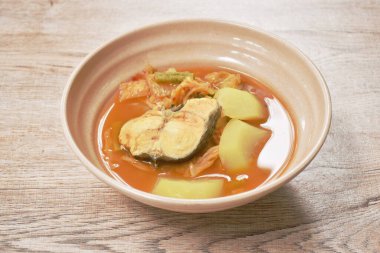  Baharatlı haşlanmış yılan başı balığı ve baharatlı çorba kasesinde karışık sebze.