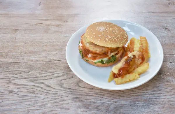  Kızarmış tavuk püresi hamburger patates kızartması soslu mayonez ve tabakta ketçap sosu.