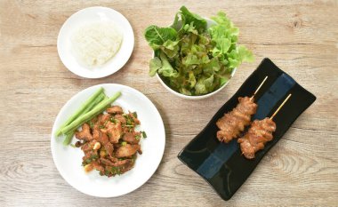  Baharatlı domuz etli Tayland salatası. Tabakta yapışkan ve taze sebzeli.