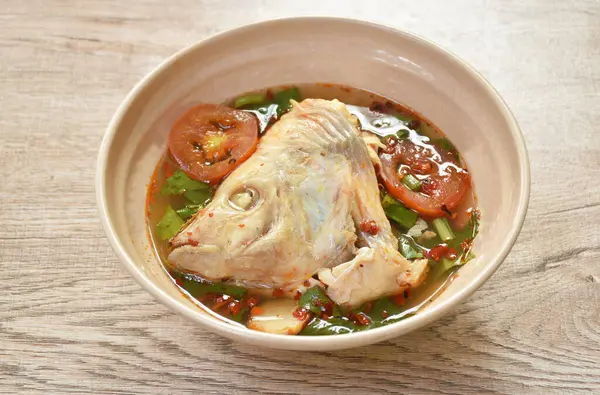  Haşlanmış kırmızı tilapia balığı esprisi domates ve Tom yum çorbasının içinde bitki.