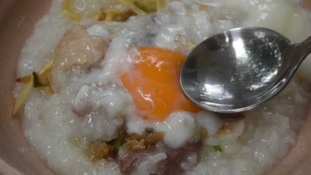 汤勺将奶油蛋黄倒在米粥杂碎的猪肉上 里面有猪油 碗里有肝脏顶置生姜 — 图库视频影像