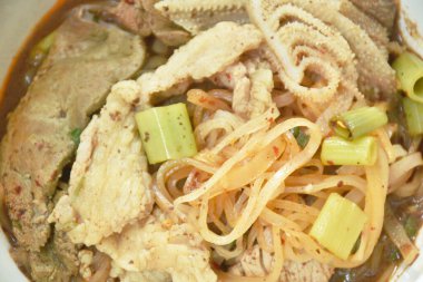  İnce pilavlı erişte dilimlenmiş sığır eti ve karaciğer kahverengi çorba kasesinde.