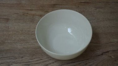 Masanın üzerinde kırık kahverengi yumurta kabuğu var.