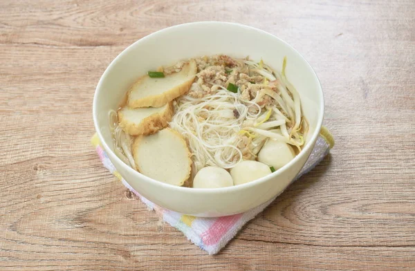 vermicelli rice noodles topping chop boiled pork and fish ball in soup on bowl