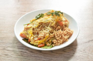  Kızarmış pirinç eriştesi, sebzeye sarılmış yumurta, üstüne de dilimlenmiş domuz eti.