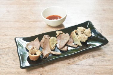 Baharatlı ve acı soslu domuz pirzolası ile haşlanmış bağırsaklar.