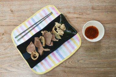 Baharatlı ve acı soslu domuz pirzolası ile haşlanmış bağırsaklar.  