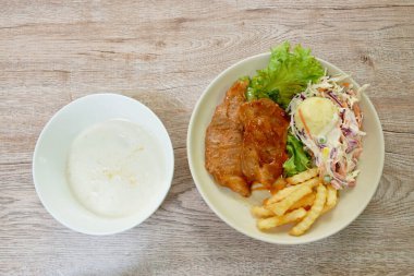 Izgara domuz eti soslu barbekü sosu patates püresi ve tabak üzerinde salata kasede mısır çorbası.