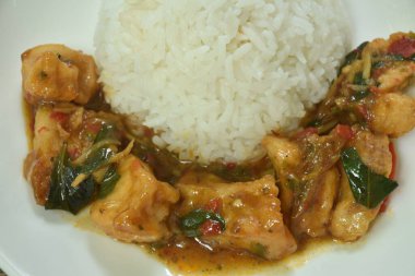 Baharatlı kızarmış levrek, beyaz parmak köklü ve tabakta pilavlı kırmızı biber.