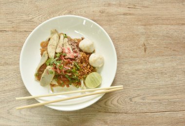 Kızarmış pirinçli şehriye ile domuz köftesi soslu kuru karides ve siyah soya sosu tabakta. 