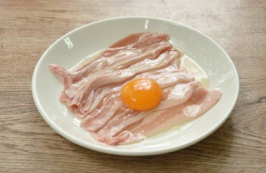 Çiğ domuz eti, tabakta yumurta.