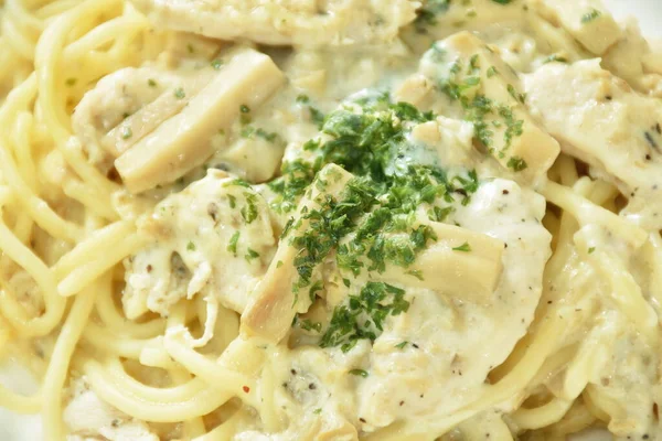 steamed spaghetti with white truffle mushroom cream sauce topping slice chicken breast on plate