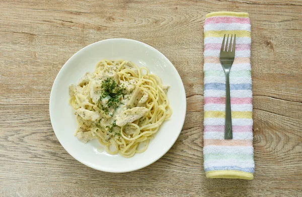 steamed spaghetti with white truffle mushroom cream sauce topping slice chicken breast on plate