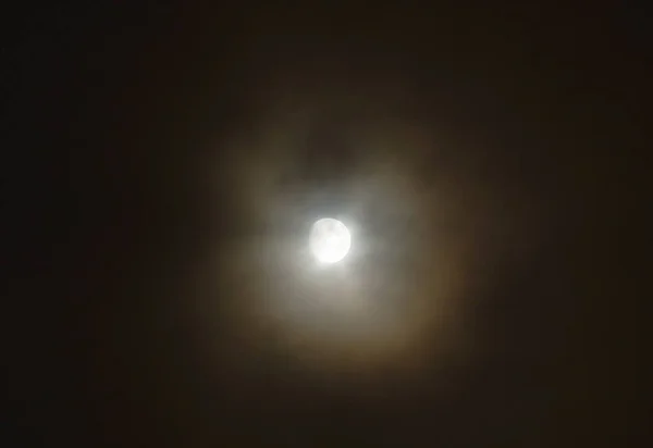 夜间透过铺张的云彩遮蔽满月 — 图库照片