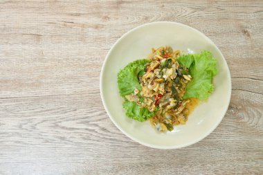 Kızarmış midyeleri tabakta acılı biber ezmesiyle karıştırın.