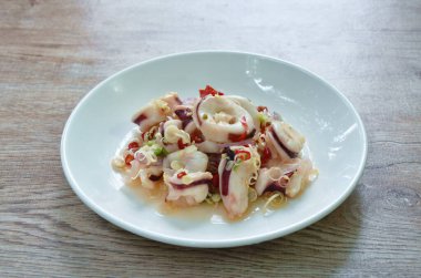 Thai spicy and sour steamed slice squid and lemon grass salad on plate 