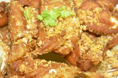 Dilimlenmiş hamur ya da kırmızı Tilapia balığı ve beyaz arka planda sarımsak tabağı.