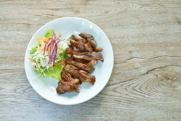 Izgara domuz eti soslu barbekü ve tabakta salata.   