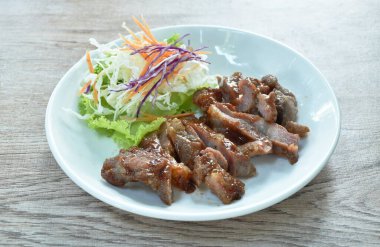 Izgara domuz eti soslu barbekü ve tabakta salata.   