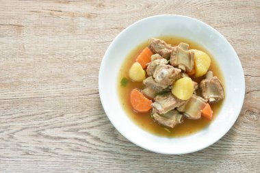 boiled pork bone with potato and carrot stew on plate