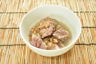 steamed pork bone topping slice ginger and ham in gravy sauce on bowl 