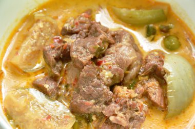 spicy boiled beef meat with eggplant in coconut milk green curry soup on bowl