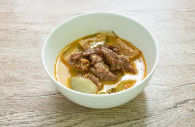 spicy boiled beef meat with eggplant in coconut milk green curry soup on bowl