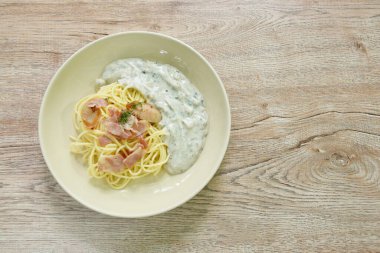 steamed spaghetti with white truffle mushroom cream sauce topping slice pork sausage and bacon on plate  