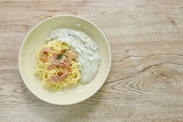 steamed spaghetti with white truffle mushroom cream sauce topping slice pork sausage and bacon on plate  