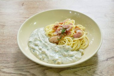 steamed spaghetti with white truffle mushroom cream sauce topping slice pork sausage and bacon on plate  