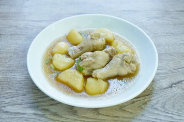 Haşlanmış tavuk budu ve soslu patates tabakta güveç.