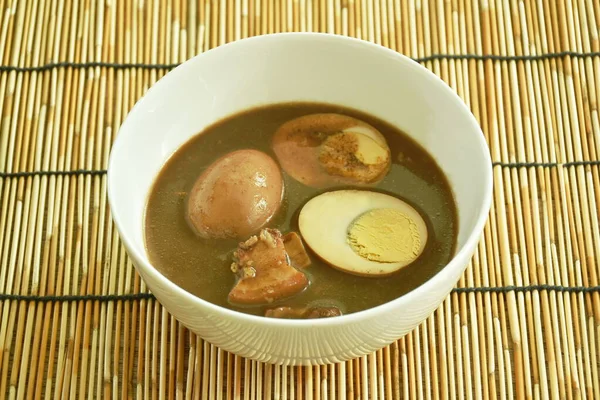 半熟半熟卵に豚脂を入れたハーブブラウンスープをボウルに入れ — ストック写真