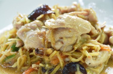 Dilimlenmiş zencefilli kızarmış tavuk ve tabakta siyah kulak mantarı. 