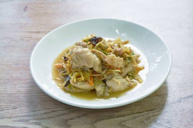 Dilimlenmiş zencefilli kızarmış tavuk ve tabakta siyah kulak mantarı. 