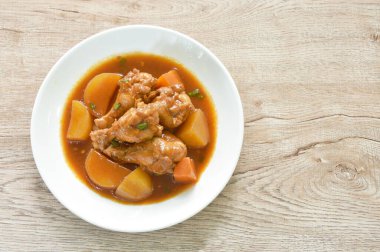 Haşlanmış tavuk budu, patates ve soslu sos tabağında güveç.