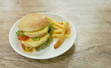 Kızarmış domuz peynirli hamburger ve patates kızartması.