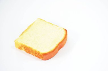 Tereyağlı cheesecake beyaz arkaplanda kare şeklinde kesiliyor