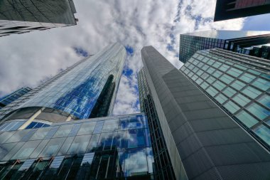 Modern gökdelenler, Avrupa, Almanya ve Frankfurt 'un finans bölgesinde kurumsal ve ticari binalar. Bulutlu gökyüzüne karşı yüksek cam binaların manzarası