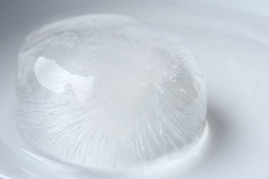 Eriyen bir buz küpü, beyaz arkaplan