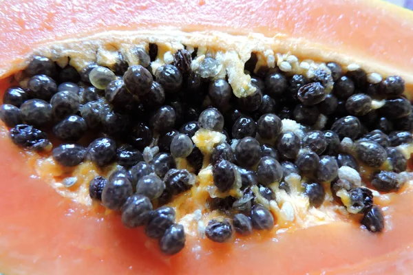 半角に切ったパパイヤの果実の黒の種のクローズアップ — ストック写真